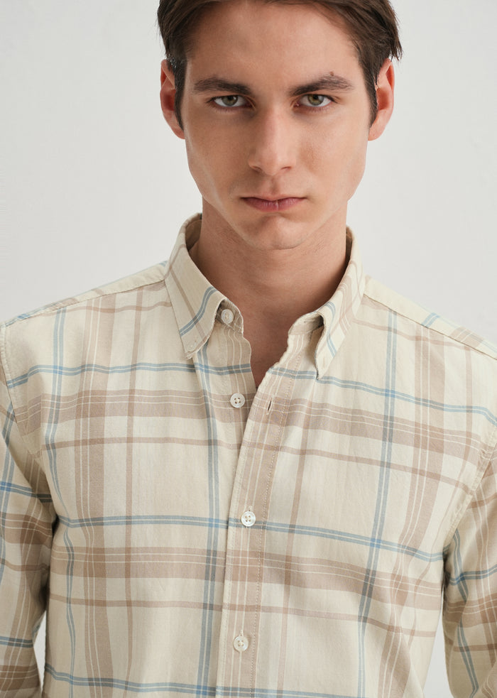 Man wearing a plaid shirt against a plain background