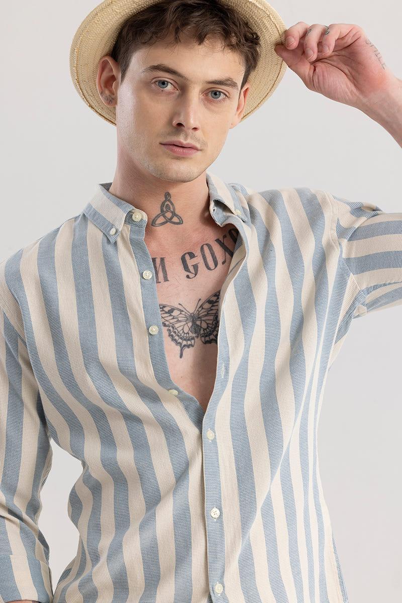 Man wearing a striped shirt and straw hat against a plain background