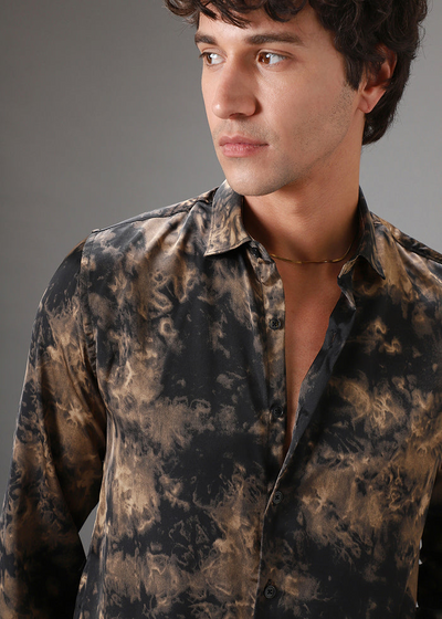 Man wearing a patterned shirt against a gray background