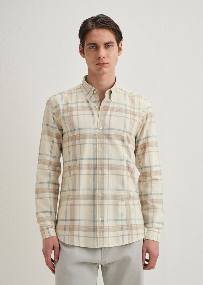 Man wearing a plaid shirt on a plain background